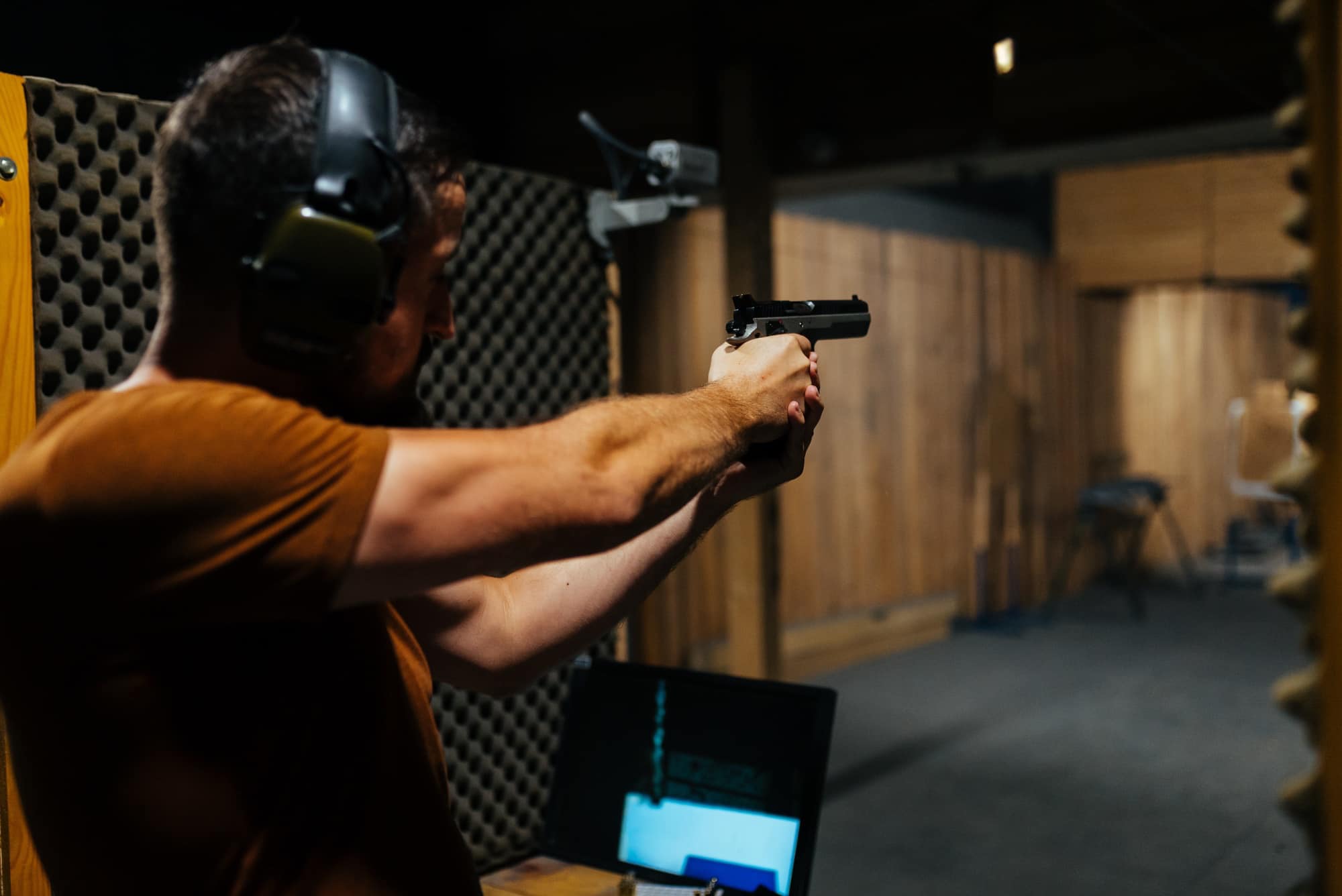 man holding handgun firing down range-stock