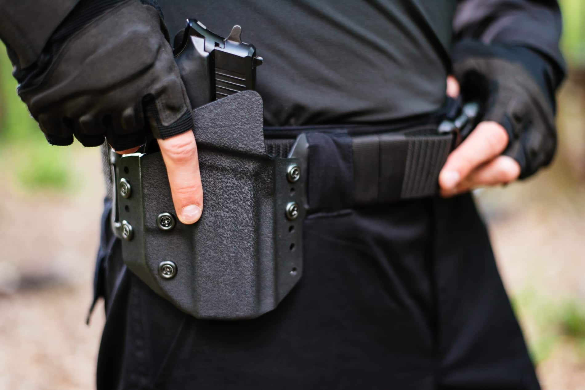 man holding handgun in holster-stock