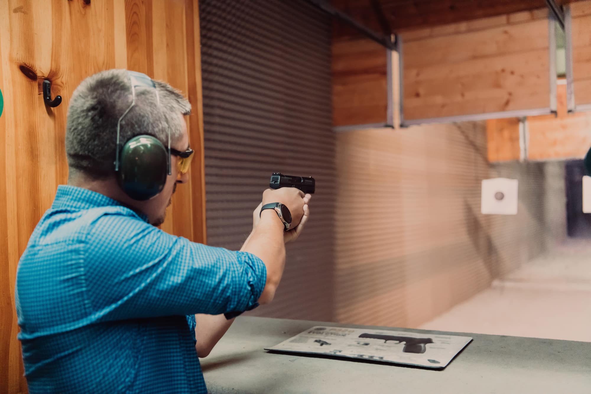 man shooting pistol wearing eyes and ears-stock