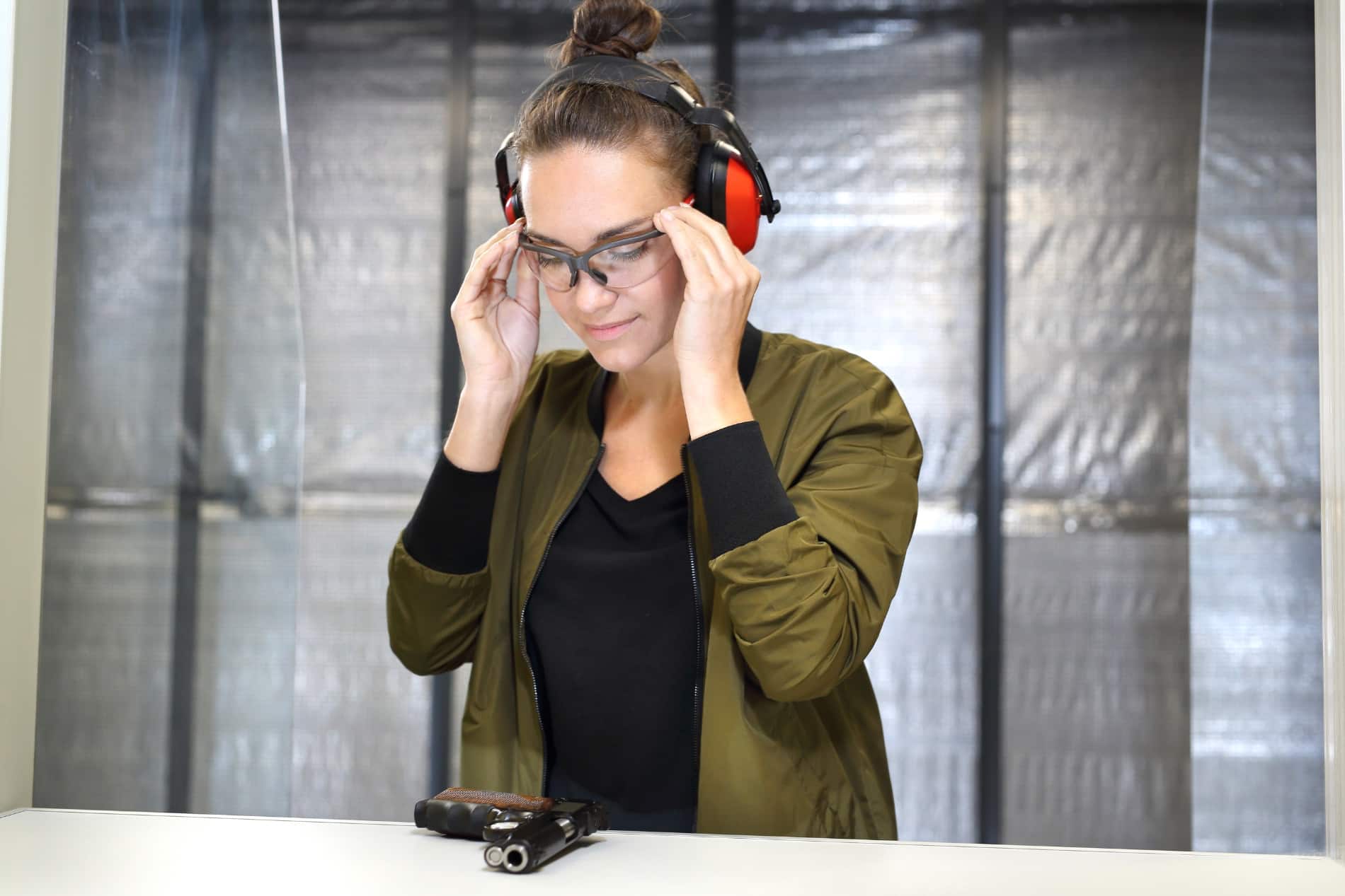 woman putting on eye protection before shooting-stock